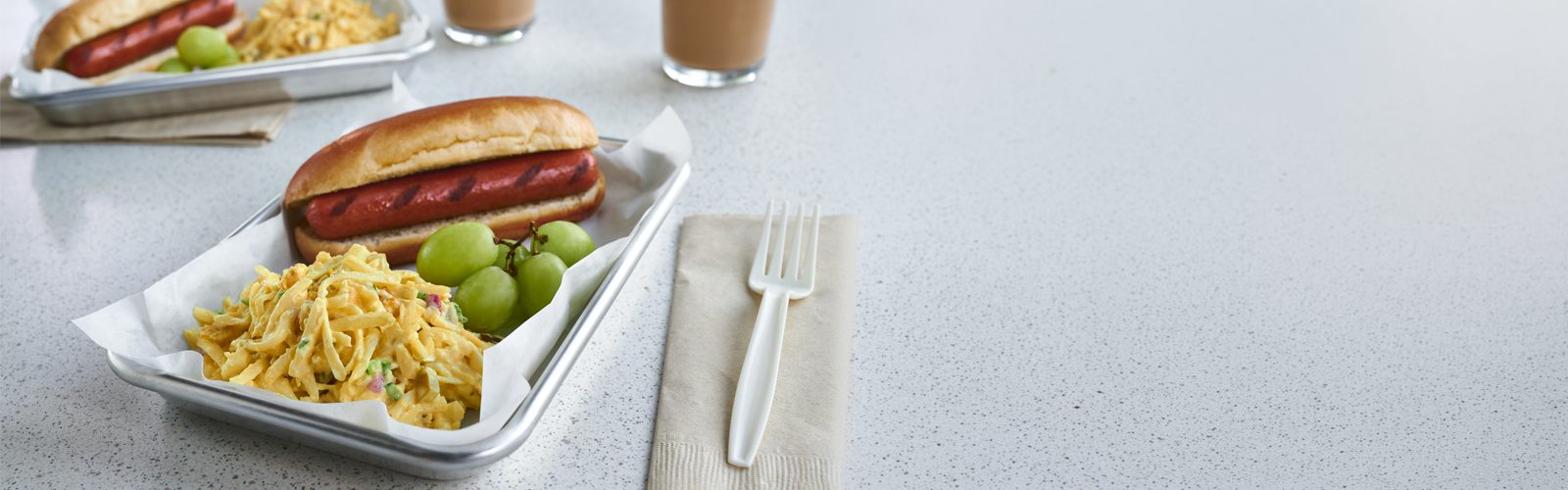 School lunch tray with a hot dog, potato salad and grapes