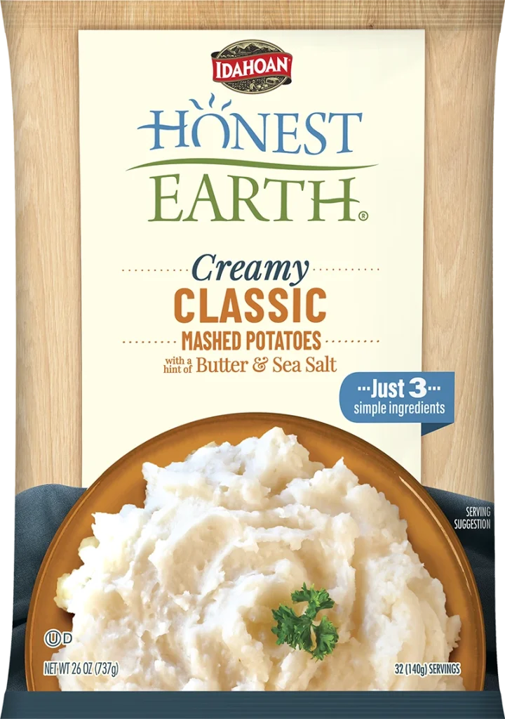 A 2022 Front Page package of Idahoan Honest Earth Creamy Classic Mashed Potatoes, featuring mashed potatoes with parsley garnish. The label highlights just 3 simple ingredients and contains 32 servings.