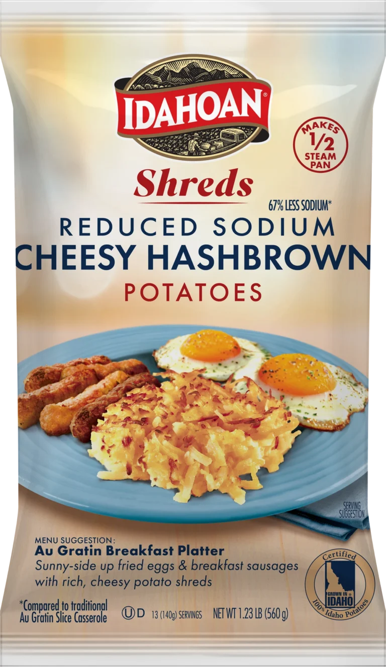 A package of Idahoan SHREDS Reduced Sodium Cheesy Hashbrown Potatoes, featuring an appetizing image of cheesy hashbrowns, eggs, and sausage on a blue plate, with product details and a bold 67% less sodium label.